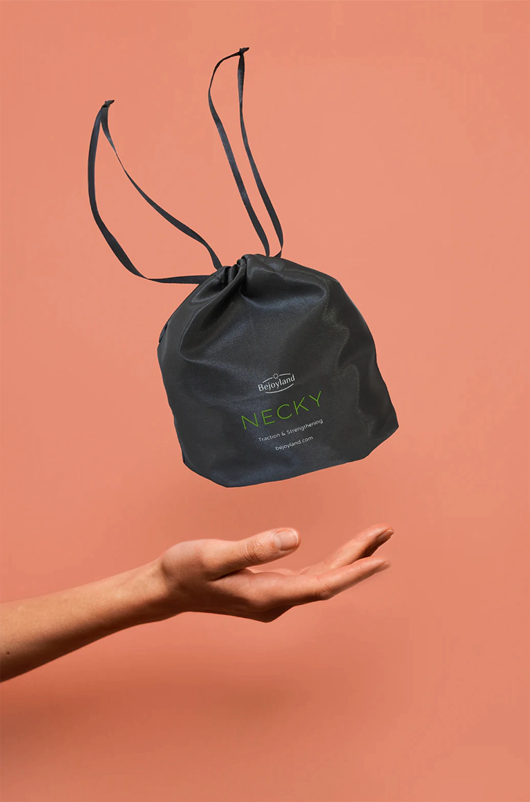 A small drawstring bag with the portable neck trainer labeled Bejoyland NECKY levitates above a hand.